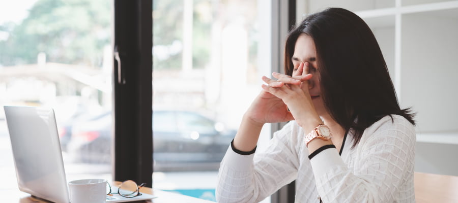 A frustrated young asian life science professional feeling stressed holding head with hands, after receiving a medical device FDA product recall.