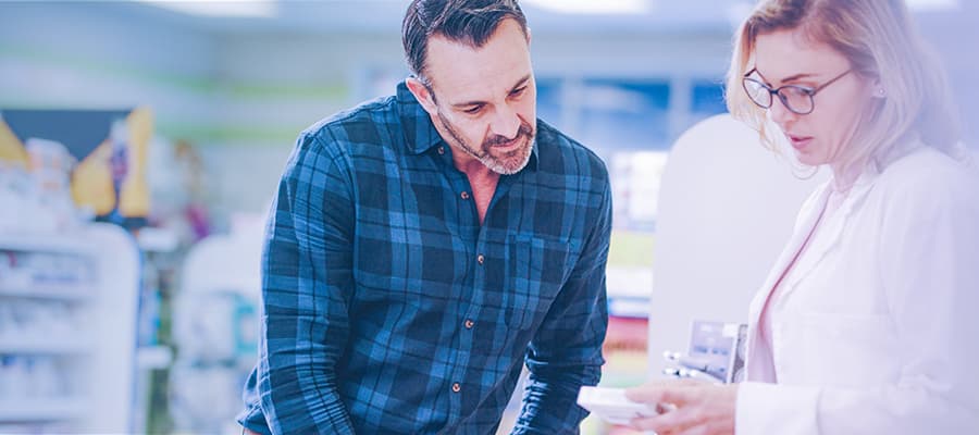 Pharma trends – patient centricity - Image of a pharmacist showing medication to a patient