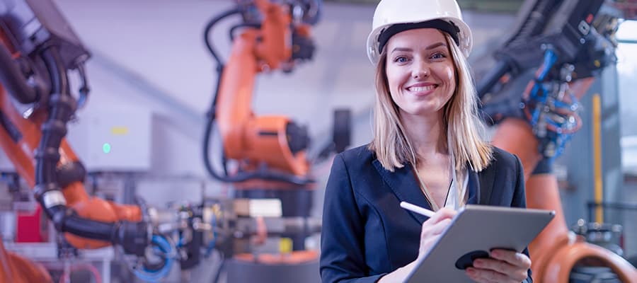 Female life science professional in modern manufacturing environment analyzing manufacturing insights.
