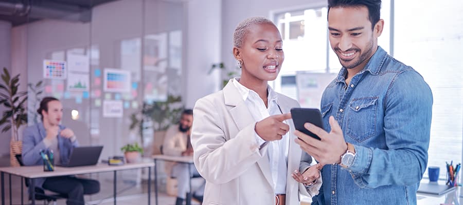 Team of life science professionals review digital quality management articles on a portable device.