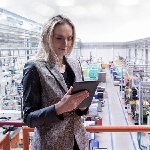 Business woman using tablet on manufacturing floor