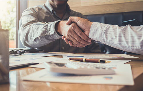 Shaking hands over investment paperwork